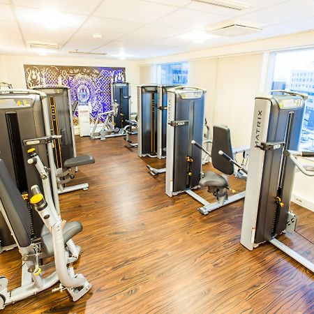Radisson Collection Hotel, Reval Exterior foto The photo shows a modern fitness room equipped with several gym machines. The space has a wooden floor and large windows that provide natural light and a view of the outside. The equipment appears to be designed for strength training, with various ma