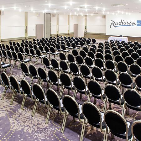 Radisson Collection Hotel, Reval Exterior foto The photo shows a large conference room setup with rows of black chairs arranged facing a stage or presentation area at the front. The room has a light-colored carpet with a decorative pattern and is well-lit, featuring ceiling lights. In the backgro
