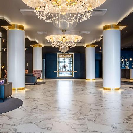 Radisson Collection Hotel, Reval Exterior foto The photo shows a stylish hotel lobby with a modern design. It features elegant chandeliers hanging from the ceiling, which provide soft lighting. The floor is made of light-colored marble, adding a touch of luxury. In the foreground, there are dark 