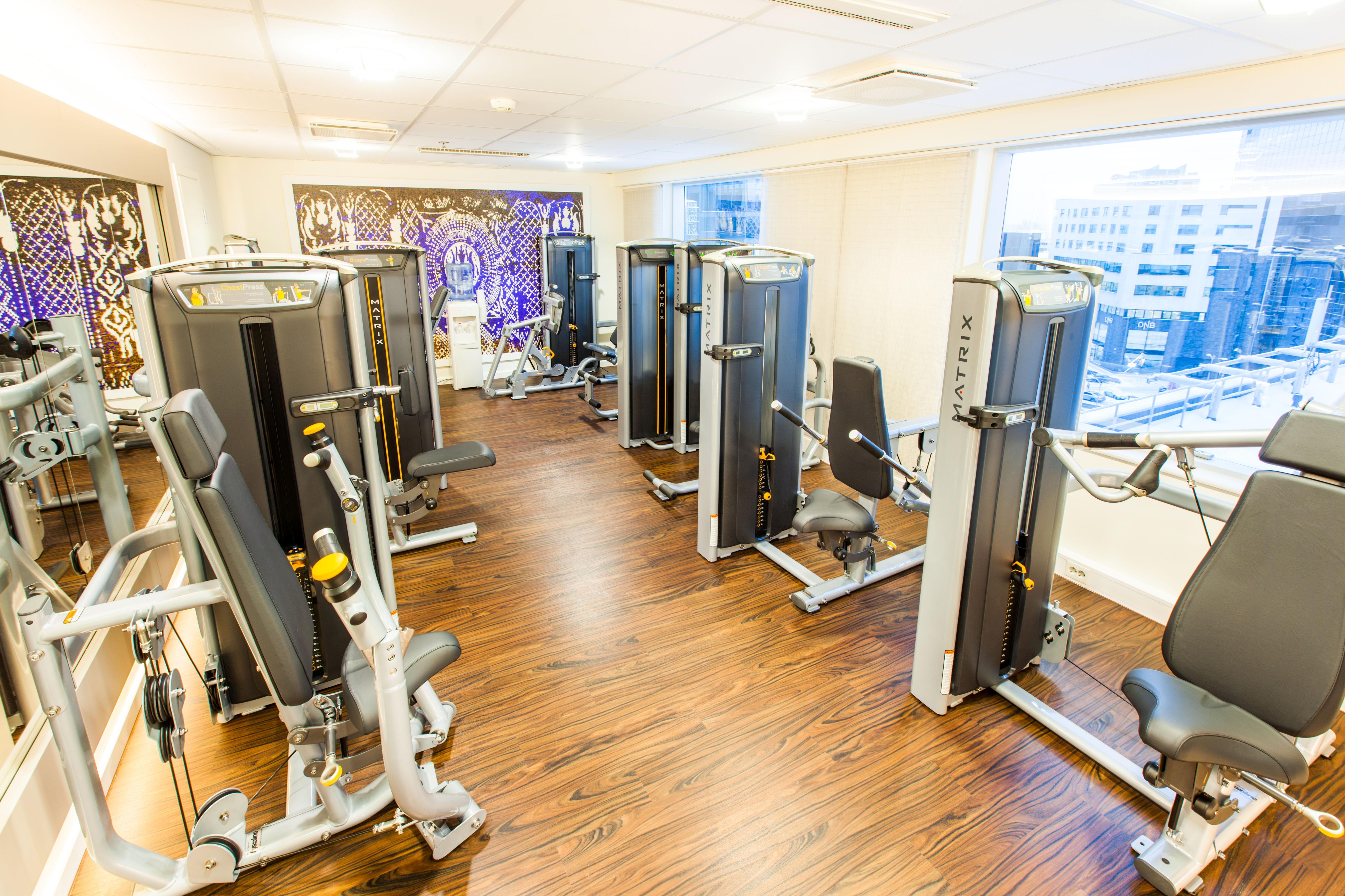 Radisson Collection Hotel, Reval Exterior foto The photo shows a modern fitness room equipped with several gym machines. The space has a wooden floor and large windows that provide natural light and a view of the outside. The equipment appears to be designed for strength training, with various ma